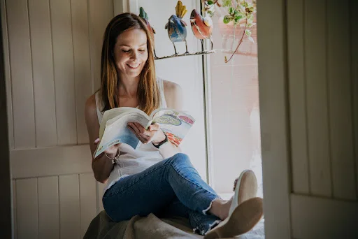 Jorgelina Pérez leyendo sobre nutrición en un ambiente cálido y luminoso.